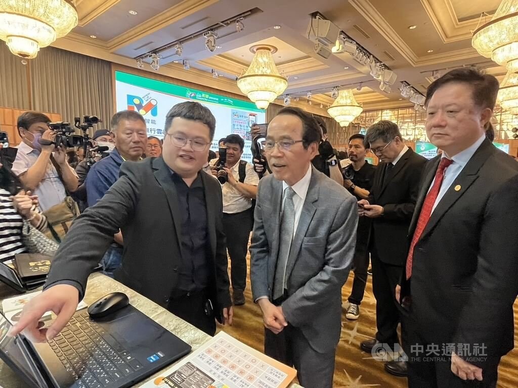 「2025高雄智慧城市展」20日起一連3天將在高雄展覽館登場,副市長林欽榮(前中)14日出席展前記者會,與設攤廠商交流,討論AI相關應用。