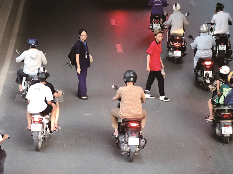 在越南過馬路是一大挑戰，汽機車、行人互不相讓，行人必須懂鑽、敢拚，將近身不到一公尺的機車與汽車視為無物，才能成功過馬路。