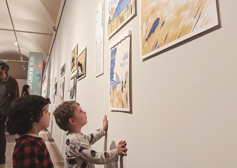「當兩個海洋相會在波隆那」特展開幕首日，義大利孩童好奇觀察台灣圖像創作者林小杯作品。（中央社王寶兒）