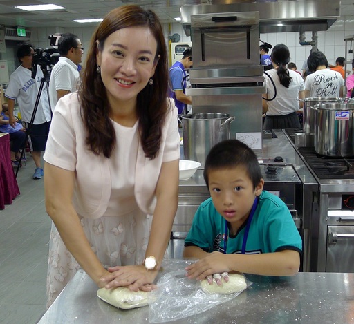 桃園市客家局長蔣絜安(左)與小學生一起同樂,將麵粉揉製成彈性極佳的麵糰。