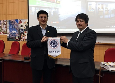 圖為龍華科大觀光系主任胡光復(左),致贈校旗予日方代表三重縣觀光局谷德彥(TANI Norihiko)。