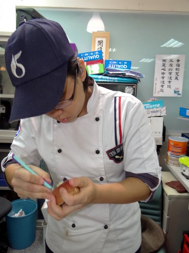對果雕非常有興趣的陳嘉智正專心用蘋果雕花。