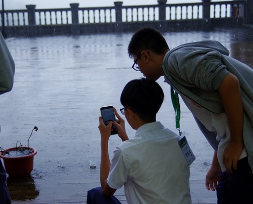 及人學生立刻兩人一組,自主學習,走出教室進行實作課程,雖然煙雨濛濛,仍然興致高昂撐傘走進雨中取景,也有學生發現枯荷之美蹲下拍攝,體會「一個鏡頭就是一個眼睛」的生命感動。