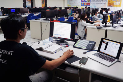 大葉大學財金系張椿柏老師(左)另外準備一台筆電,確認線上教學系統是否同步