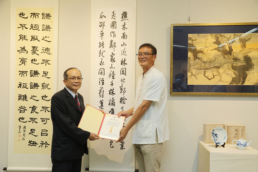 黃緯中(右)老師致贈書法作品一幅予中興大學藝術中心,由興大黃振文副校長頒贈感謝狀。
