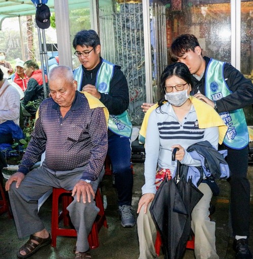 休健系鴻宗穎老師(左側站立者)帶領運動防護社同學為長者進行紓壓按摩及推拿。