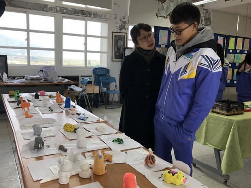 華梵大學美術與文創學系聶蕙雲副主任(左)與金山高中學生討論作品。