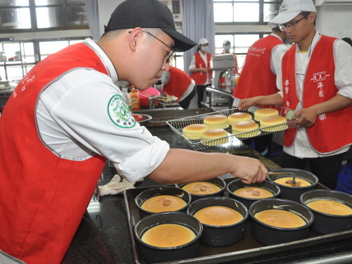 學生將學校Logo烙印在蛋糕上。