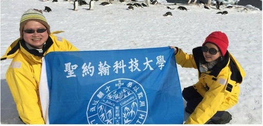 2015年12月陳萬來董事長（左）前往南極探險，特地將聖約翰科大校旗攜至南極，無論身在何處，精神都與母校同在。