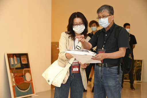 「取色賦形.捨像傳神-陳銀輝90藝術歷程」展覽布展中,策展人廖仁義(右)及劉碧旭(左)討論作品配置情形