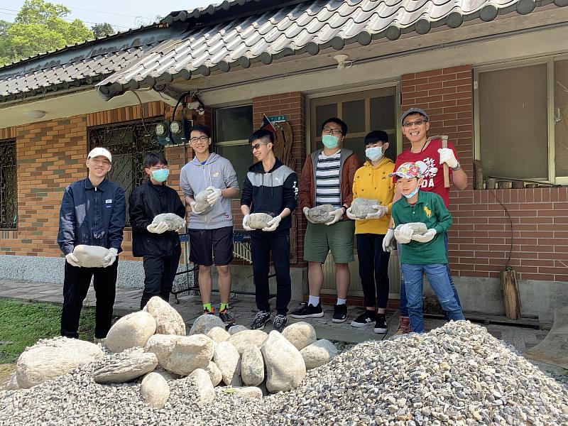 學生搬運石頭堆防坡堤