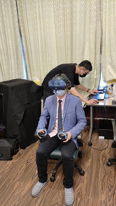 客傳會董事長陳邦畛親自戴上AR VR裝置，體驗特展作品。
