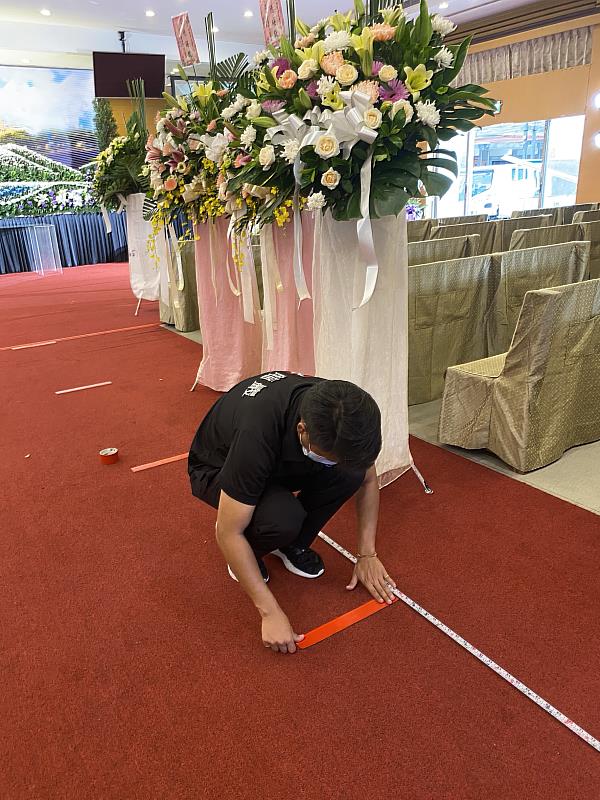 工作人員前一天在現場貼好定位貼，以確保參加公祭之人員皆能嚴守室內1.5公尺的防疫社交距離