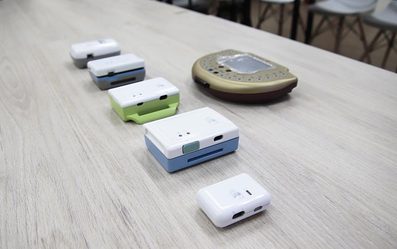 中大研發團隊歷代腦波機展示，第七代外觀只有菸盒大小，兼具科技美學造型（如右前方所示）。