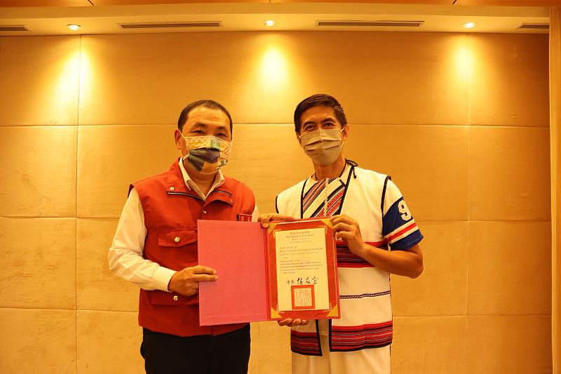 ▲侯友宜市長(左)頒發首屆語發會委員聘書，右為陳大衛委員身著泰雅族服裝。(圖新北市政府原民局提供)