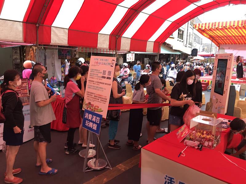 現場許多民眾都在排隊，等著想要體驗kiosk互動式智慧機台的轉盤抽獎遊戲。
