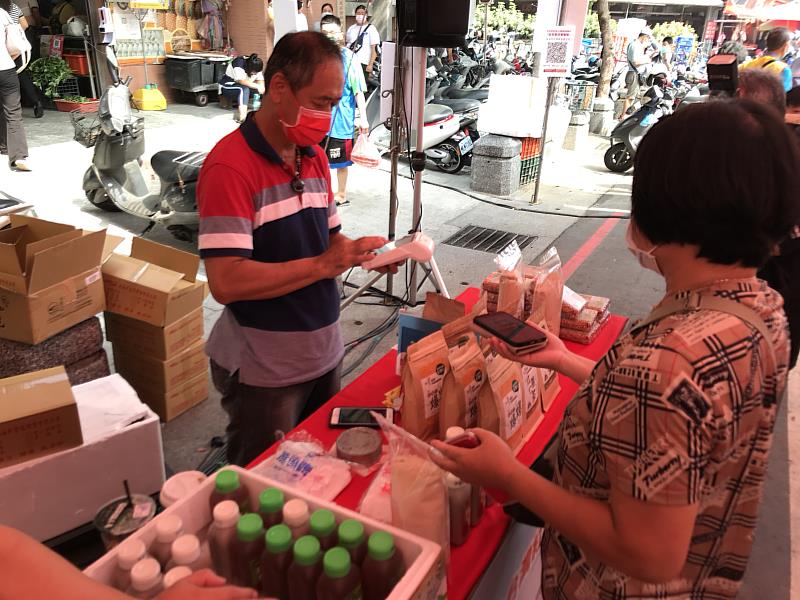 大甲第二市場的攤商體驗「智慧型行動支付收款機」的方便與安全。