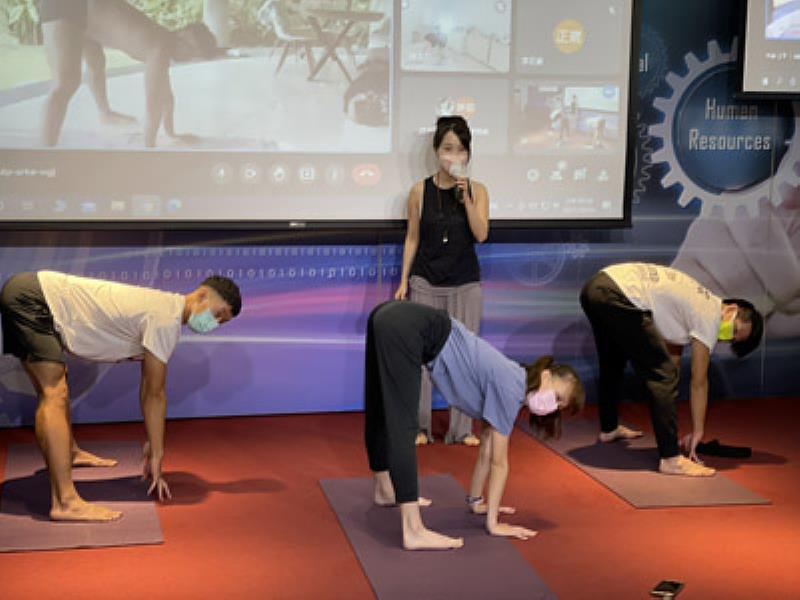 口譯老師Belle Cheng(後方)在教室引導大葉大學學生跟隨印度老師做瑜珈