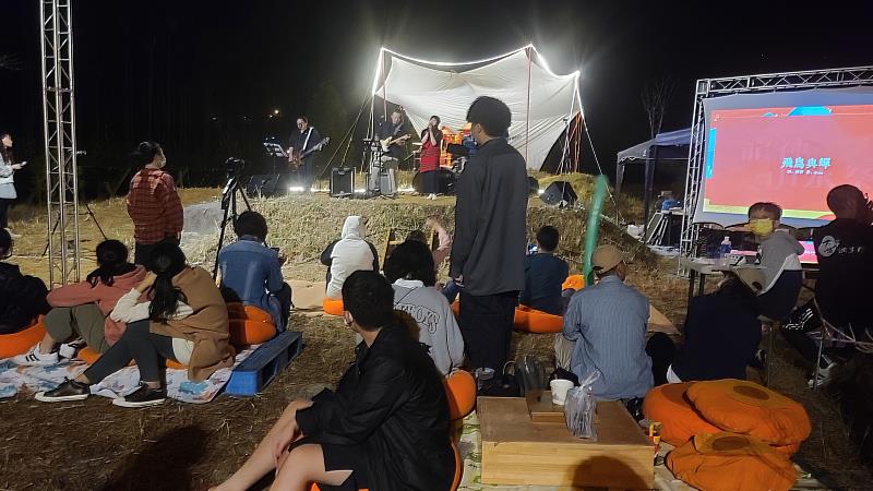 到了傍晚，遊客紛紛前往草地音樂會，坐在柿子枕上面，悠閒聆聽樂曲。