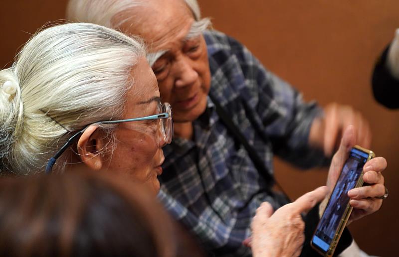 廖年賦教授(右)與陳明律教授(左)討論省交老照片中的人物