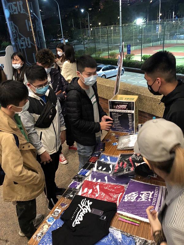 義守大學「一三七」週邊系列商品攤位買氣旺，深受學生歡迎(資料畫面來源：義守大學提供)。