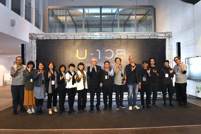 貴賓手比U象徵U-108空間之合影情形，左6為國家歌劇院藝術總監邱瑗、左7為文策院副院長張文櫻、左8為國美館長永斐、右7為臺中市政府文化局副局長施純福、右6為彰化師範大學美術學