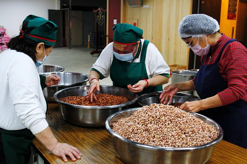 基隆講堂志工與貢寮社區媽媽一同仔細篩選食材，確保每一碗臘八粥都是美味與安心。（靈鷲山佛教教團提供）