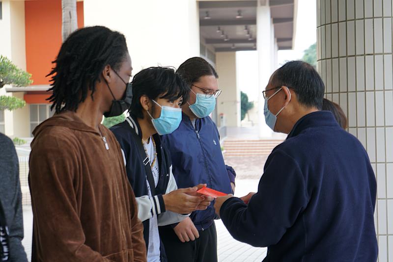 莊岳峰國際長(右)為國際生發放紅包並送上祝福