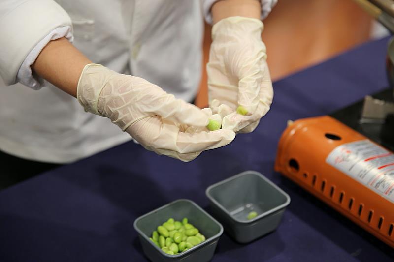 將毛豆仁煮約五到十分鐘後，去除毛豆外層的薄膜，再把去膜的毛豆放入果汁機或食物調理機，加入鮮奶油和糖，攪打至泥狀。