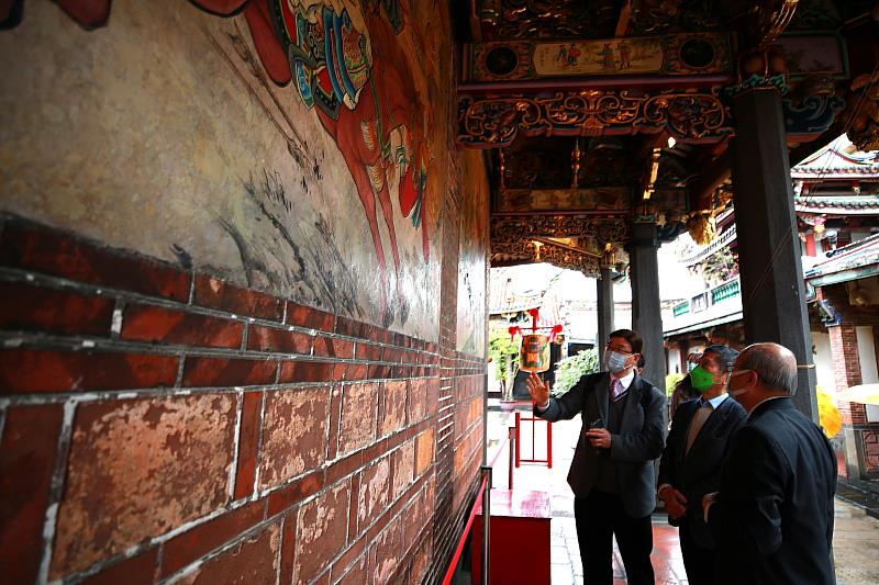 保安宮正殿迴廊的壁畫，為已故彩繪名家潘麗水於1973年之創作。保安宮董事長廖武治（右）帶領文化部長李永得（中）及文資局副局長粘振裕參觀畫作修復情形。