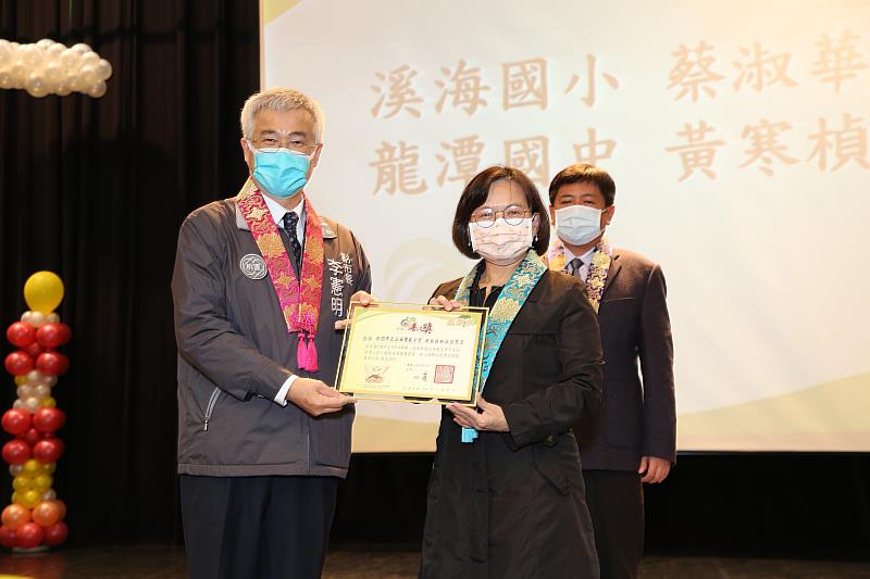 今年獲得推動品德教育楷模獎的蔡淑華（右），連續六年推薦學生參加普仁獎，由桃園市副市長李憲明頒獎。（圖由靈鷲山佛教教團提供）