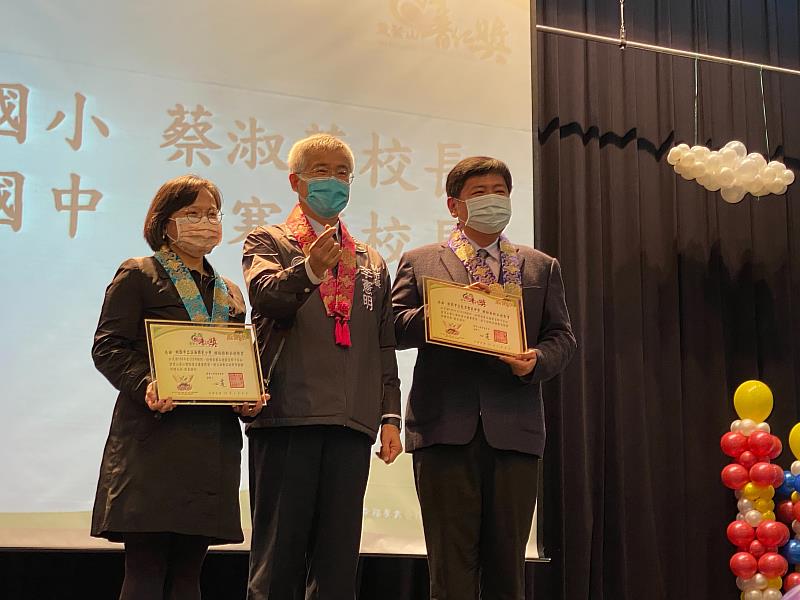 桃園市副市長李憲明與獲得推動品德教育楷模獎的溪海國小校長蔡淑華（左）、龍潭國中校長黃寒楨合影。（圖由靈鷲山佛教教團提供）