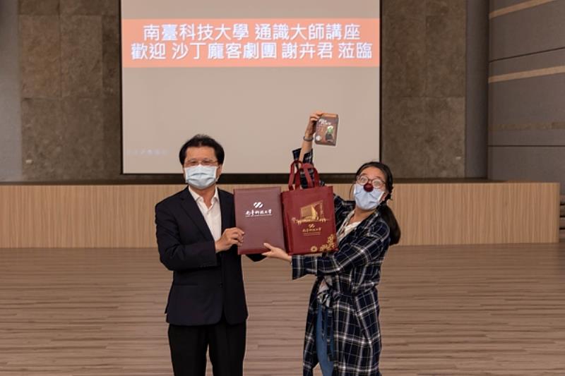 南臺科技大學副校長朱志良(左)特致贈聘書與紀念品予沙丁龐客劇團謝卉君(右)。