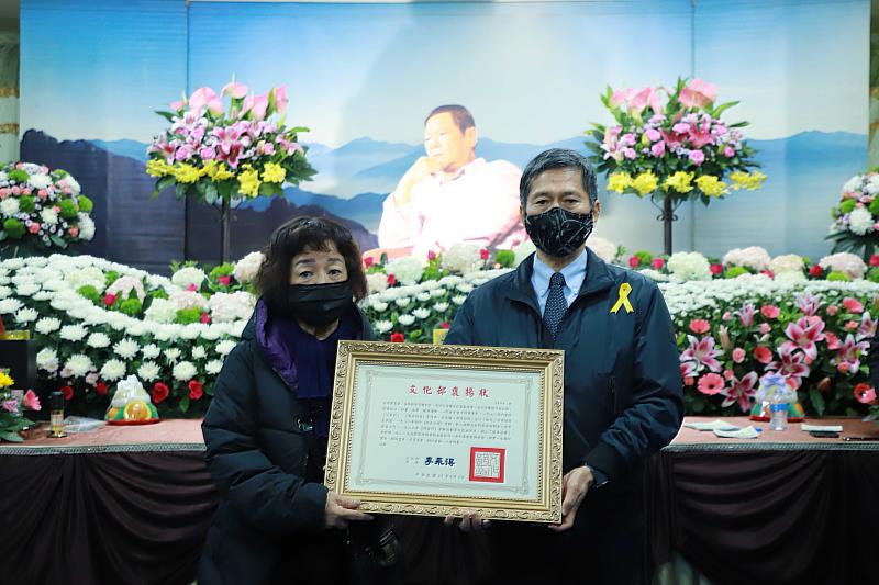 文化部長李永得(右)頒贈文化部褒揚狀，由邱晨遺孀楊麗琴代表受贈