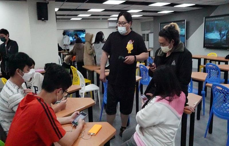 學生分組討論創作劇本時，吳震亞聽取學生想法並給予建議。