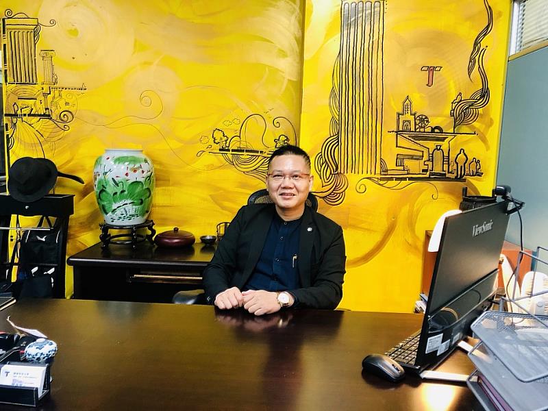 圖說二：陳逸聰主任與進修部辦公室牆面作品