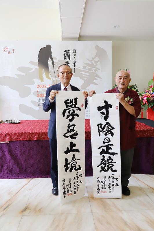 「舞墨逸生-蕭季慧雙管書法展」於南華大學震撼登場，雙管書法家蕭季慧老師(右)現場揮毫，並將墨寶致贈給南華大學。左為林聰明校長。