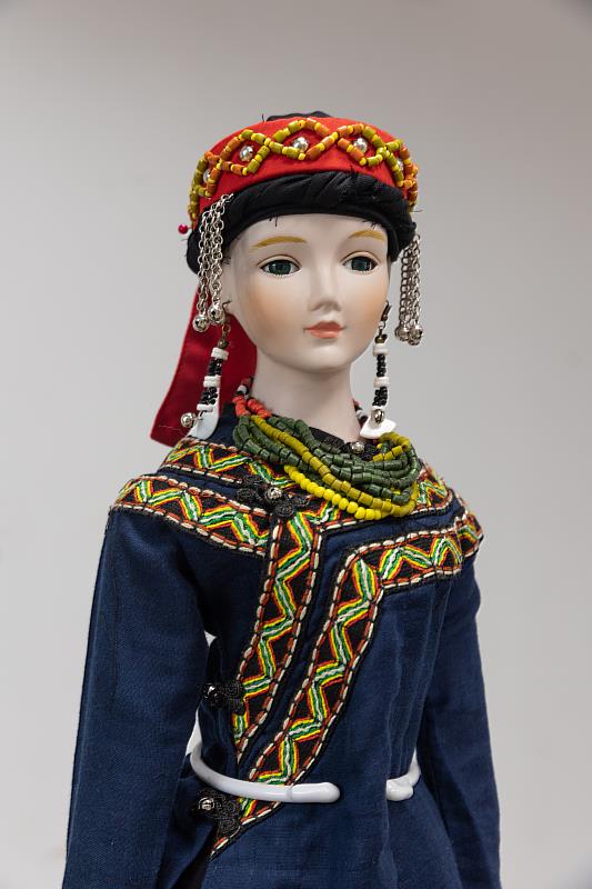 身著華麗傳統服飾、頸掛琉璃珠、頭戴族帽的排灣族娃娃。(圖/新北市政府原民局提供)