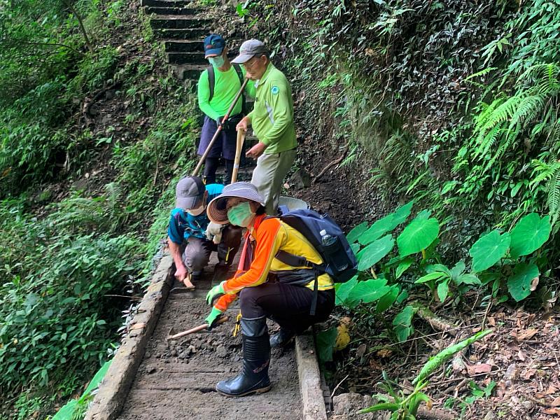志工細心清除崁頭山步道跨越橋上堆積的泥沙