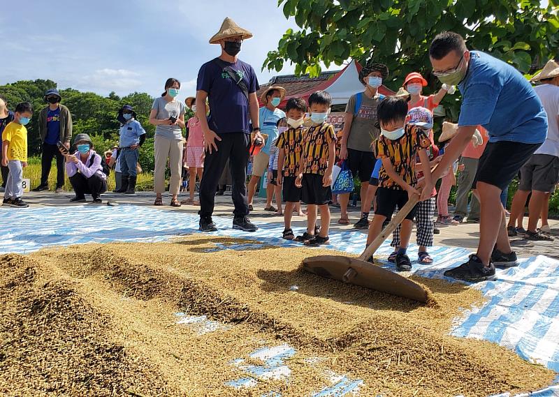 民眾在六堆園區體驗曬穀