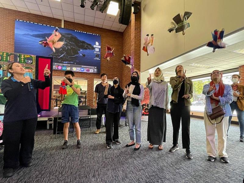 山宛然客家布袋戲團8月21日在安娜堡圖書館辦理工作坊，並由操偶師黃若茵（左1）帶領觀眾學習拋接戲偶技巧。