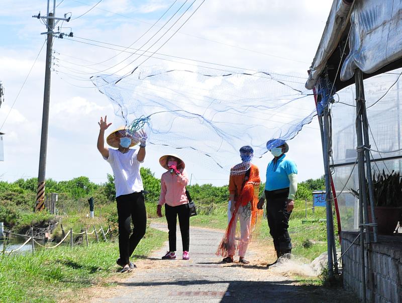 由當地民眾教導國際生在岸上練習撒網動作