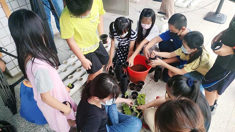 義守大學生科系師生，於國小校園建構具元素循環與生態永續概念的「魚菜藻三相共生系統」，將永續教育向下紮根(照片來源：義守大學提供)。