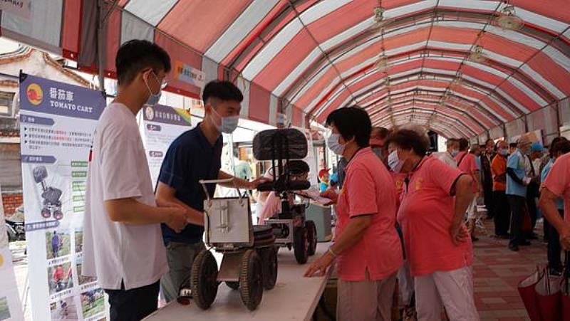 南臺科技大學電子工程系學生向社區長輩介紹歷代番茄車的改進重點與變革之情形。