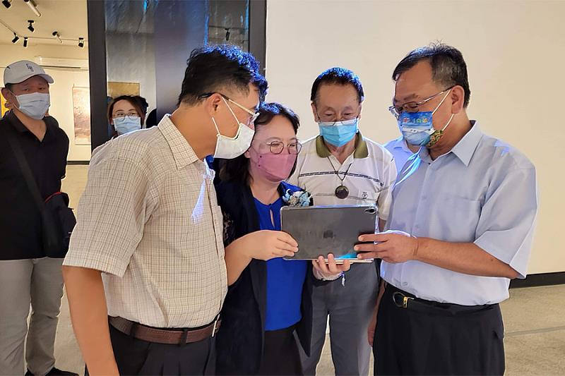 逢甲大學特聘教授鄭月妹用iPad在展場中為澎湖縣長賴峰偉(右一)解說AR互動模式。