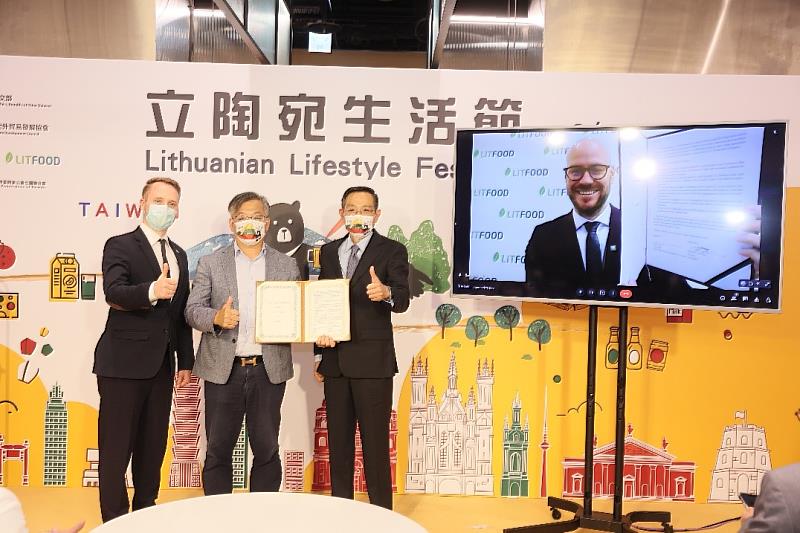 2.	中華民國食品流通商業同業公會聯合總會賴立彪理事長(左二)透過線上即時連線與立陶宛食品局局長沙盧那．什禮雪斯(Mr. Šarūnas Celiešius)(右一螢幕)簽署雙邊合作備忘錄（MOU），強化臺立食品貿易的交流與合作，由立陶宛經創部次長澤麥提斯(Mr. Karolis Zemaitis)(左一)與外交部國經司蔡允中司長(右二)共同見證。(貿協提供)