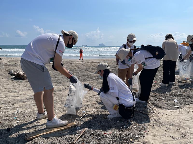 圖三：學生們頂著高溫在海灘上認真撿拾廢棄物
