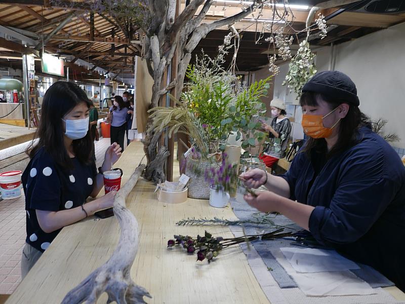 川草負責人鬆獅說在鹽一市場賣鮮花、乾燥花沒有什麼違和，且生意意外還蠻好的，目前攤位設置櫥窗展示也幫整座市場做美化。