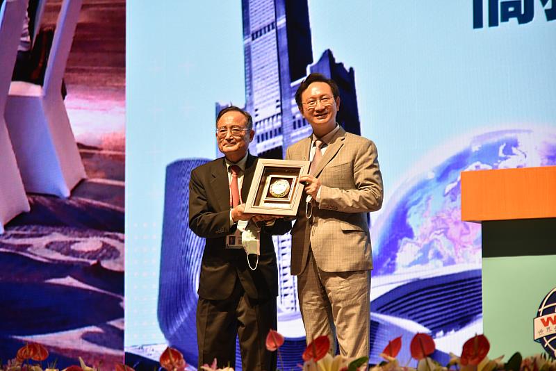 王德(左)致贈感謝獎牌給僑委會，由童振源(右)代表接受