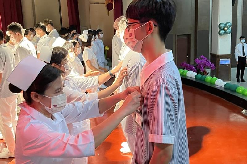 車禍受傷的朱怡蓁和楊心淳同學乘坐輪椅在台下接受系主任蔡富棉和老師加冠